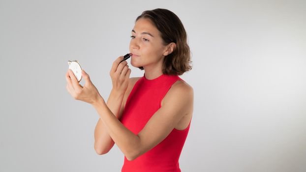 Makeup at home - a woman paints her lips with lipstick. High quality photo