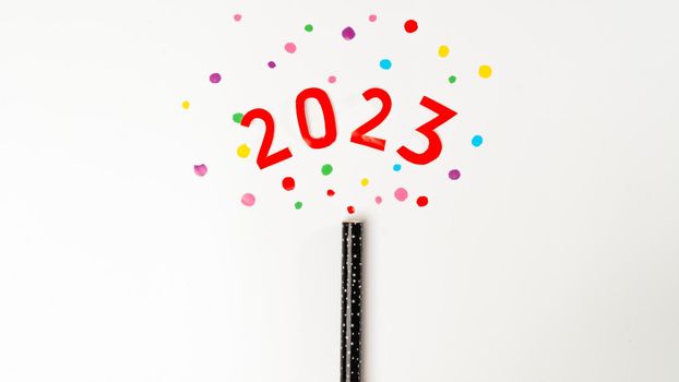 Christmas, New Year's cracker with multi-colored confetti and the number 2023 on a white background. High quality photo