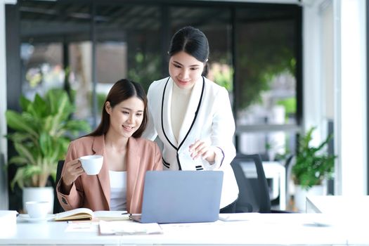 Two Young Asian businesswoman discuss with new startup project Idea presentation, analyze planning and financial statistics and investment market at office..