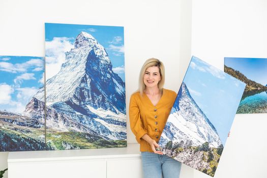 Woman hanging a photo canvas on a wall