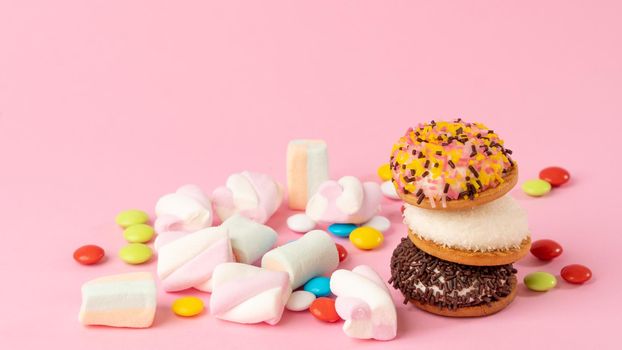 Sweets - cake, sweets, dragees, marshmallows on a pink background. High quality photo