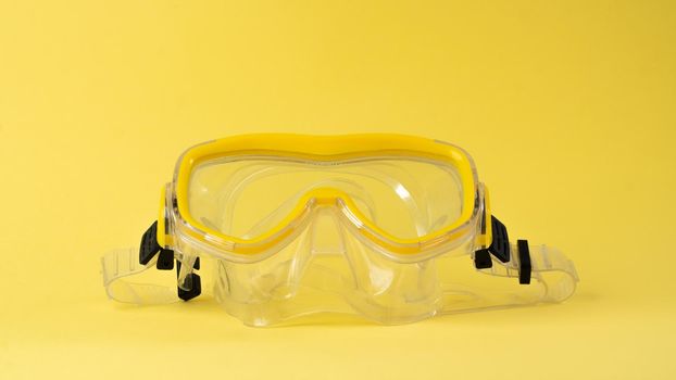 Yellow scuba diving mask on a yellow background, color aesthetics. High quality photo