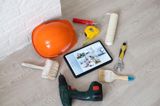 Different equipment tools of builder and tablet pc on wooden texture