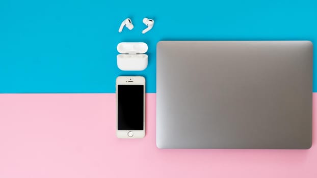 Wireless headphones, smartphone and laptop - gadgets on a two-tone background. High quality photo