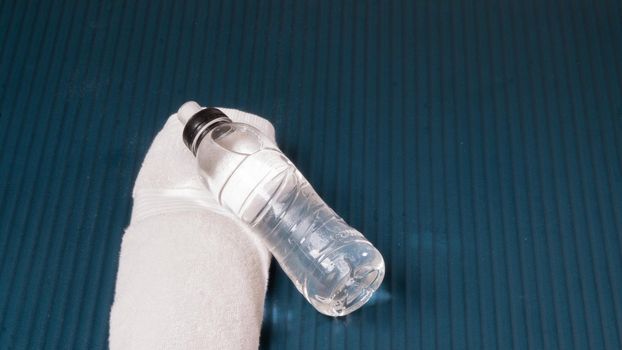 Bottle of water and towel on the mat sports background for training. High quality photo