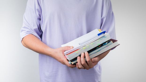 Men's hands hold a notebook, notebook, books and textbooks for classes. High quality photo