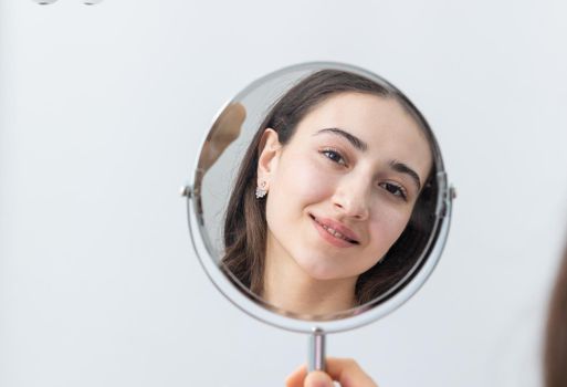 Young woman looking in a mirror after a dental procedure