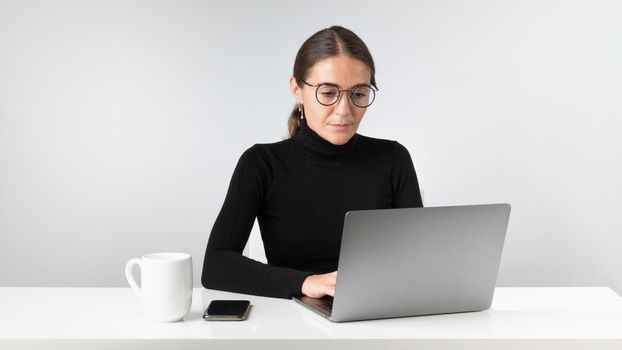 A female office employee works at a laptop. High quality photo