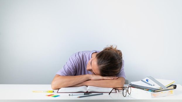 The student fell asleep at the lessons on the books. High quality photo