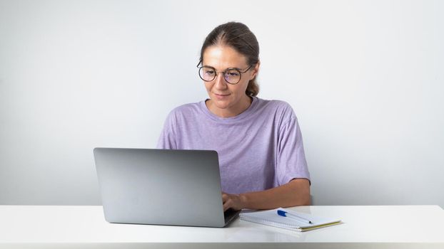 A girl typing at a laptop - remote education and work, online communication. High quality photo