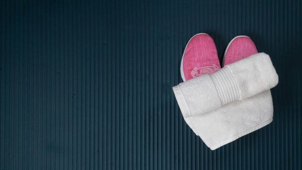Sneakers and a towel for sports on the mat for training. High quality photo