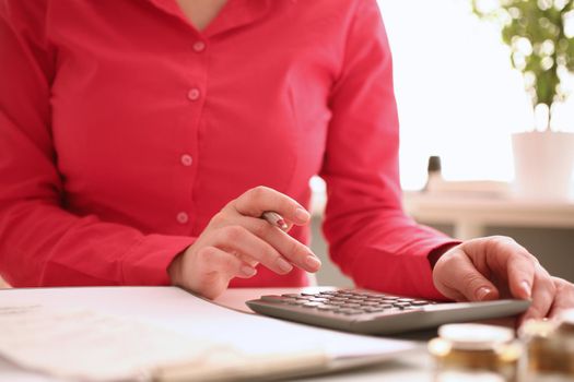 Woman secretary counts on calculator in office closeup. Business budget and company expenses
