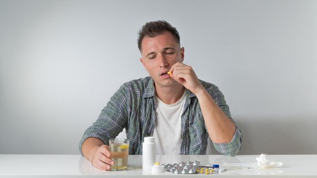 A sick man drinks a cold pill - home treatment. High quality photo