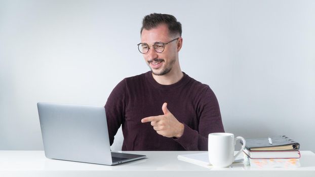 A man with glasses communicates via video call on a laptop, an online conference at work. High quality photo