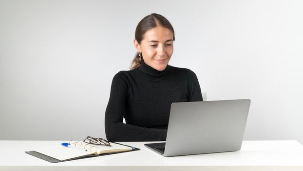 A woman works at a laptop on a white background. High quality photo