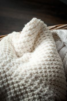 Knitwear, fabric textures and rustic lifestyle concept - Knitted winter clothes in a basket