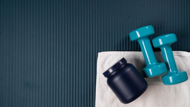 A bank of sports pit, dumbbells and a towel on the mat for sports, a place for text. High quality photo