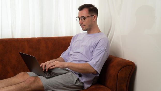 A man works at a laptop from home, remote work. High quality photo