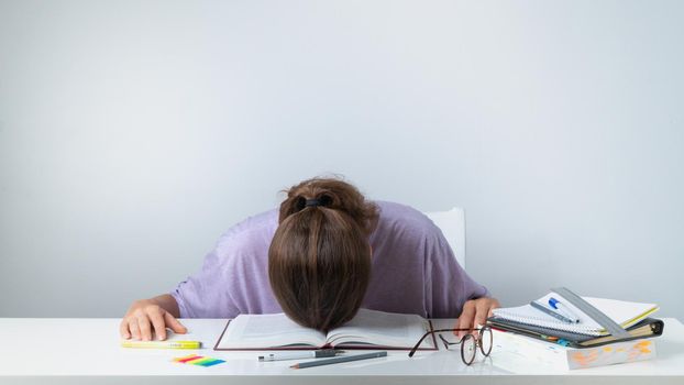 A student sleeps on a textbook - difficult study, heavy load. High quality photo