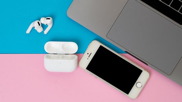 Laptop, phone and wireless headphones on a two-tone background. High quality photo