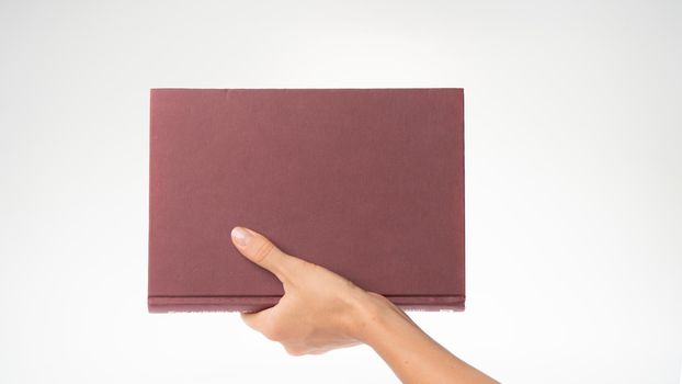 A woman's hand holds the book vertically space for the inscription. High quality photo