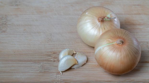 onion in husks and cloves of garlic on a wooden background vegetables. High quality photo