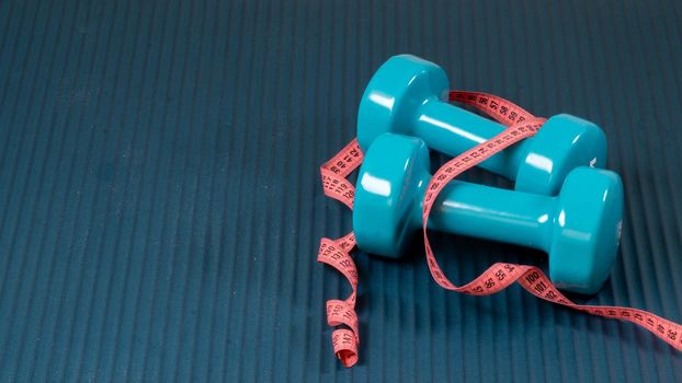 Dumbbells and centimeter on the mat background sport. High quality photo