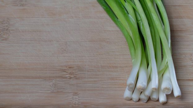 green onions feathers lie on a wooden kitchen board. High quality photo