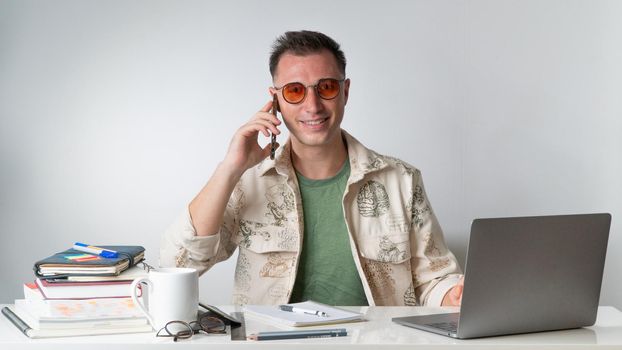 A man is talking on the phone at his desk. High quality photo