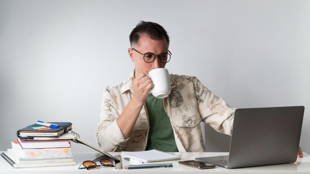 Student with a cup of coffee on his laptop - online education, freelancing. High quality photo