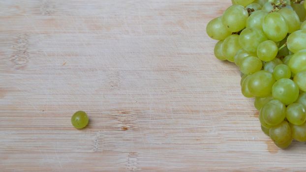 A bunch of green quiche-mish grapes on a wooden background with space for text. High quality photo