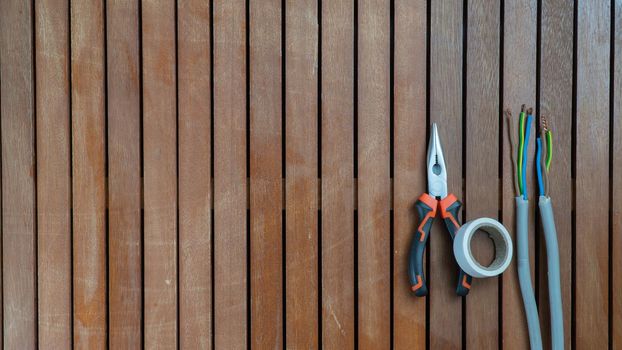 Tool set - wire cutters, wire, insulating tape on a wooden background. High quality photo