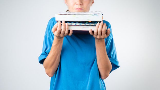 Women's chin on a stack of books and notebooks, studies. High quality photo