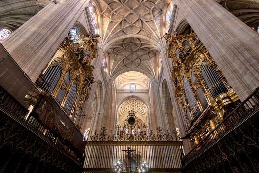 Perspective interior view of a big catholic church with a big organ and white ceiling