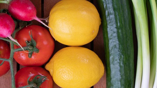 radishes, tomato, lemon, cucumber, green onions - vegetables and greens close-up background. High quality photo