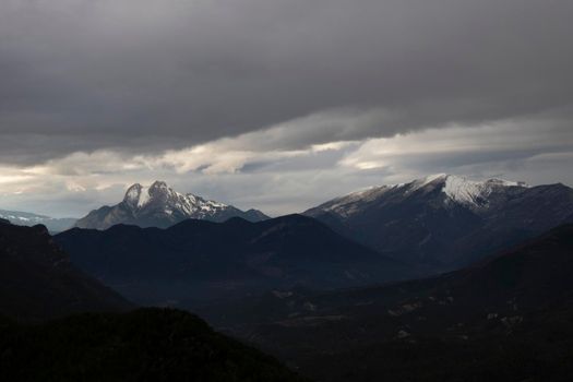 Landscape showing a couple of snowy mountains, one of them called Pedraforca, under a cloudy sky