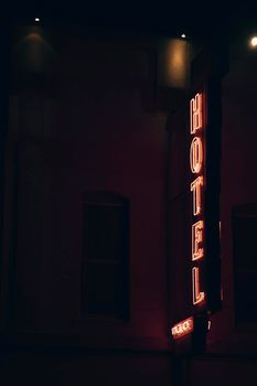 Facade of a Hotel with a window and a neon light sign