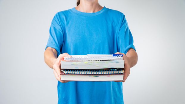 A female student with a stack of books and notebooks for classes. High quality photo