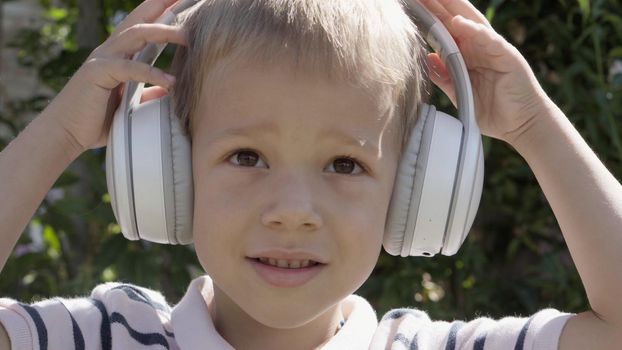 Portrait of Cute Little Boy With Headphones Listening to Music. Cheerful Carefree Childhood. Preschool Girl Feeling Free and Funky, Good Emotions Life. Child Listening to Music in Home and Dancing.