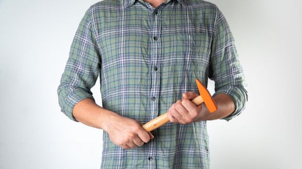 A man with a tool in his hands, a hammer on a white background. High quality photo