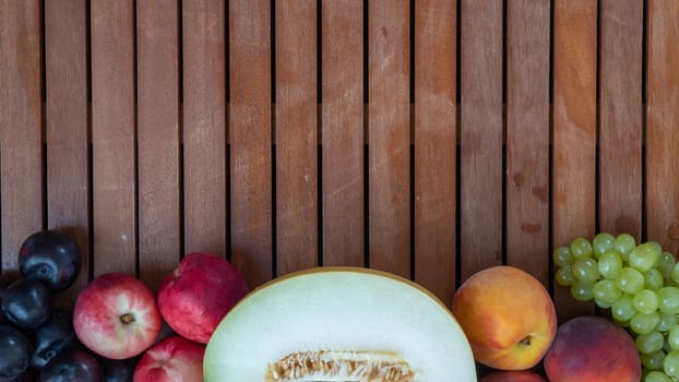 Set of fruits - melon, grapes, peaches and plum on a background of wood space for inscription. High quality photo