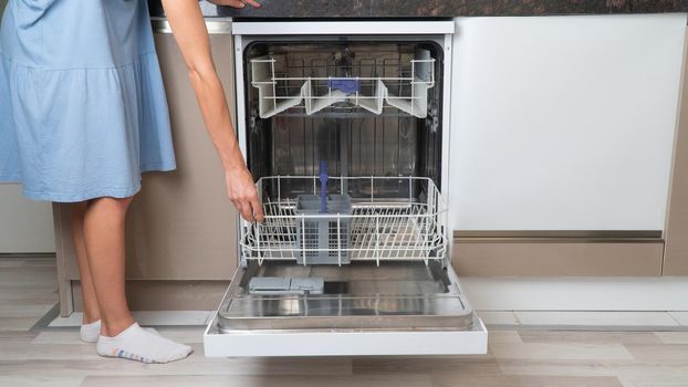 A woman opens or closes the dishwasher