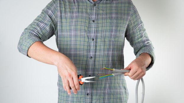 A man bites wires with wire cutters the work of an electrician. High quality photo