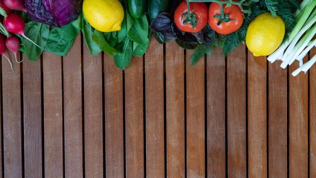 Vegetables on top wooden background radishes, lemon tomatoes onions greens. High quality photo