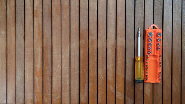 Repair tools screwdriver with bits in a case on a wooden background. High quality photo