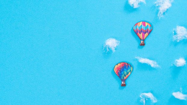 Balloons in the clouds of cotton wool on a blue background, a place for inscription. High quality photo