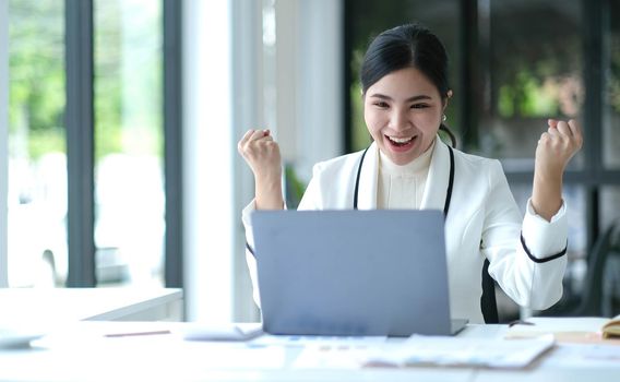 Pretty Asian businesswoman sitting on a laptop And the work came out successfully and the goal was achieved, happy and satisfied with her..
