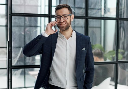 businessman with glasses talking on the phone in the office
