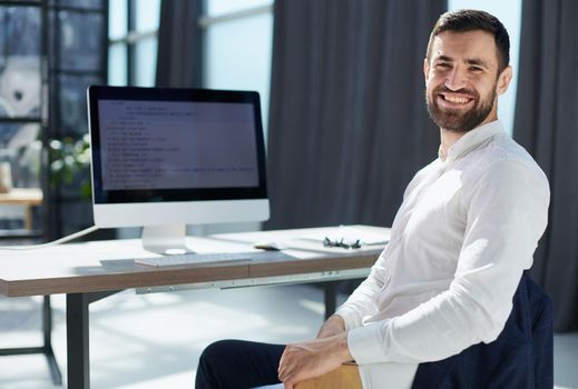 Young employee looking at computer monitor during working day in office