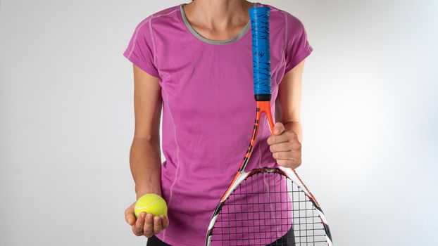 A woman holds a racket and a tennis ball. High quality photo